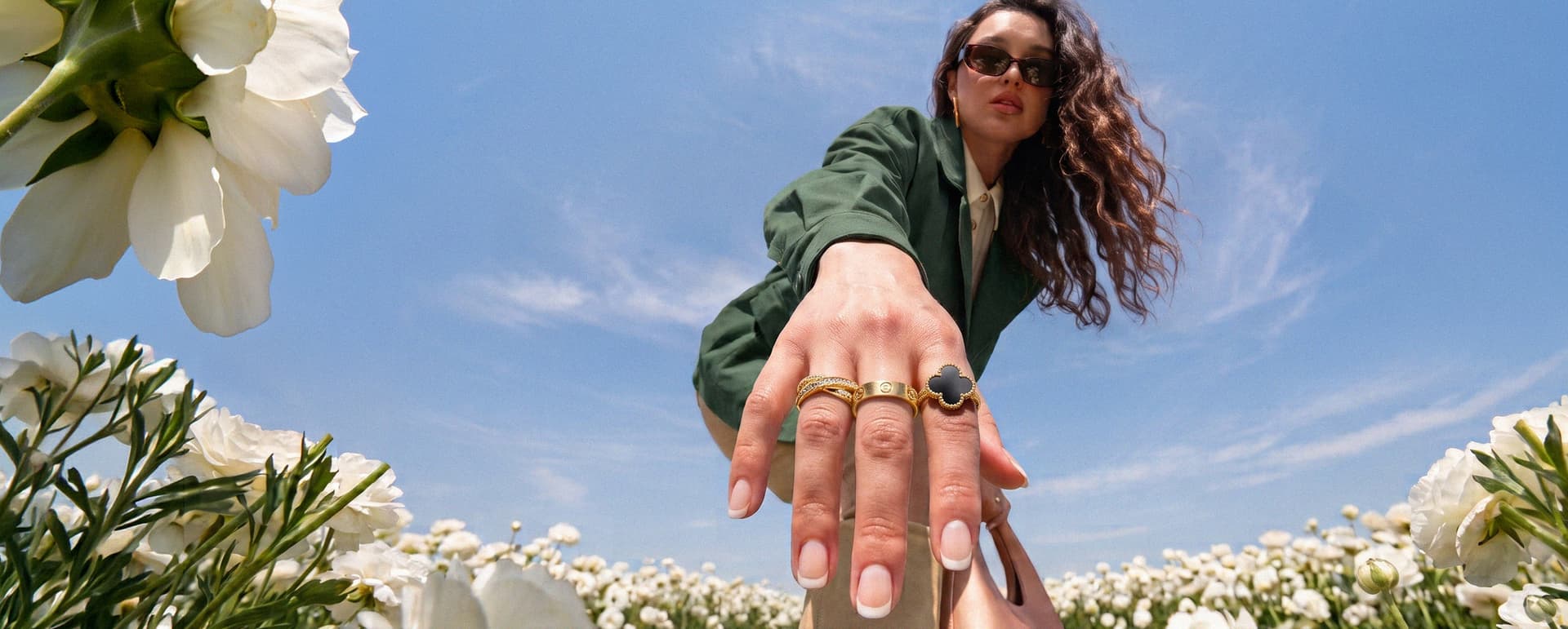 Frau mit Van Cleef & Arpels- und Cartier-Ringen in einem Blumenfeld